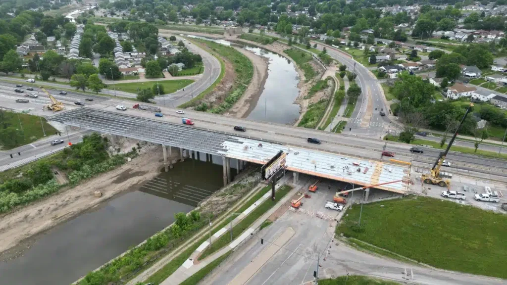 Aerial view of bridge construction underway on the I-55 corridor in Missouri, showing steel framing, construction crews, and active traffic on the adjacent lanes.