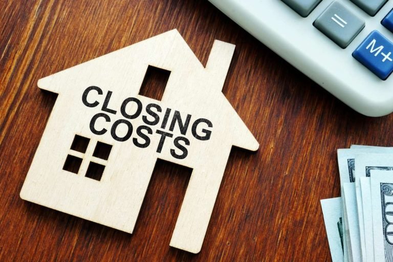 Wooden house-shaped cutout with the words 'Closing Costs' next to a calculator and stack of hundred-dollar bills