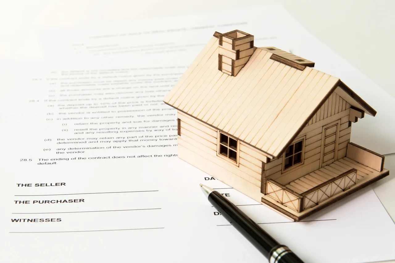 Miniature house on a mortgage contract with pen, symbolizing preapproval process