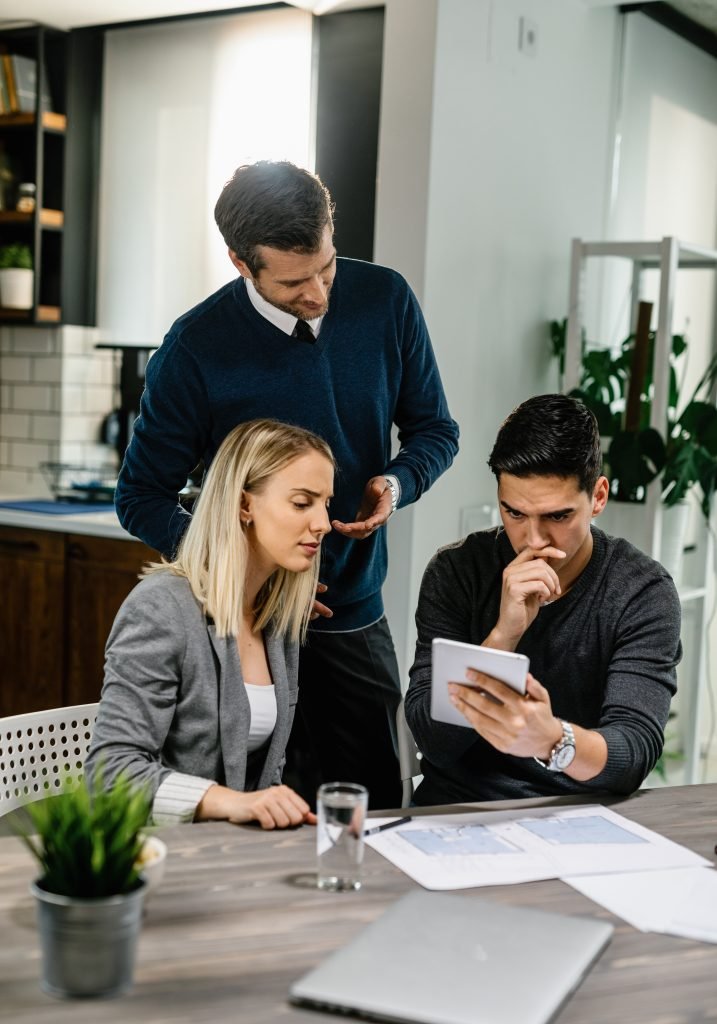 young couple feeling uncertain while using digital tablet meeting with their insurance agent home