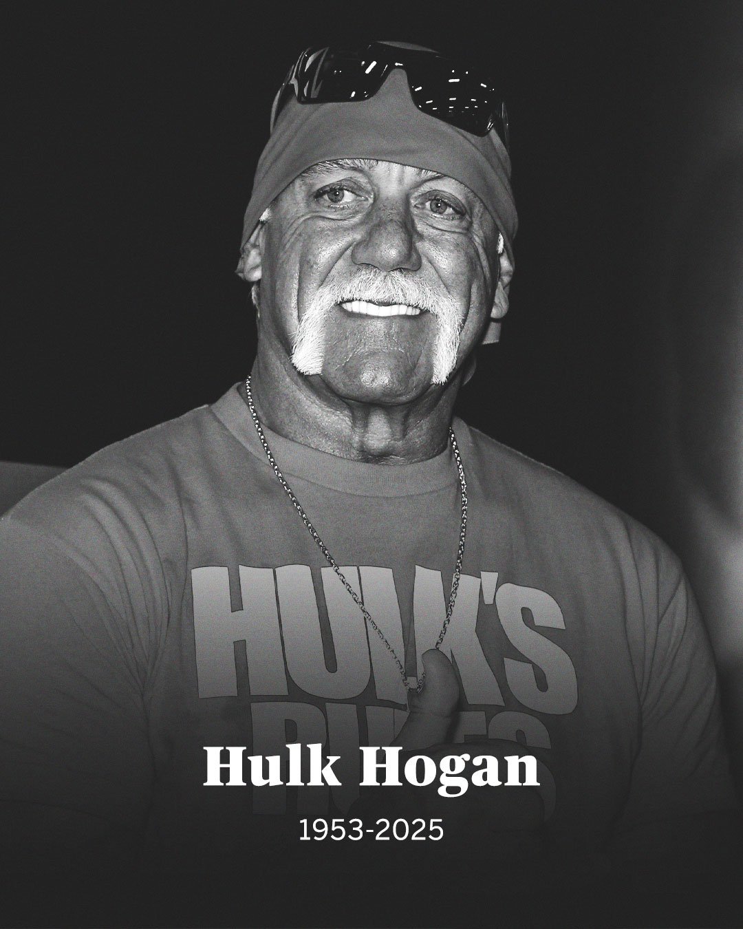 Black and white memorial photo of Hulk Hogan smiling with sunglasses on his head, honoring his legacy following the Hulk Hogan death announcement in 2025.