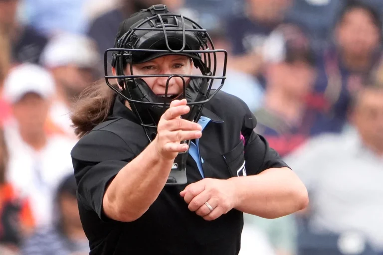 First female MLB umpire Jen Pawol calling a play behind home plate during a game