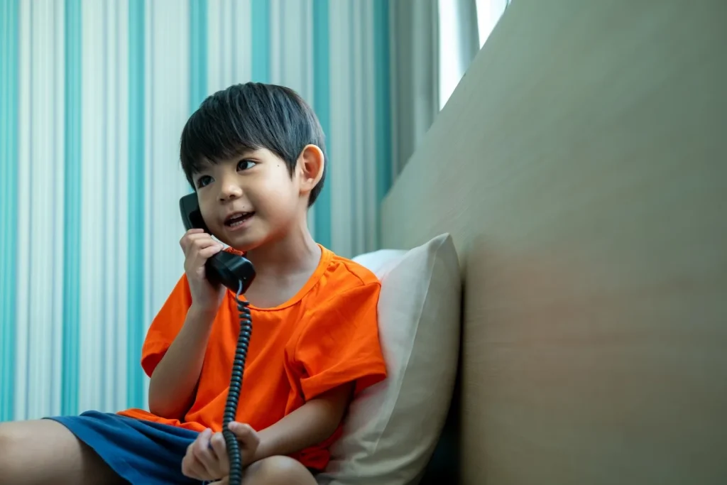 Child using a landline phone at home after Missouri smartphone ban in schools.