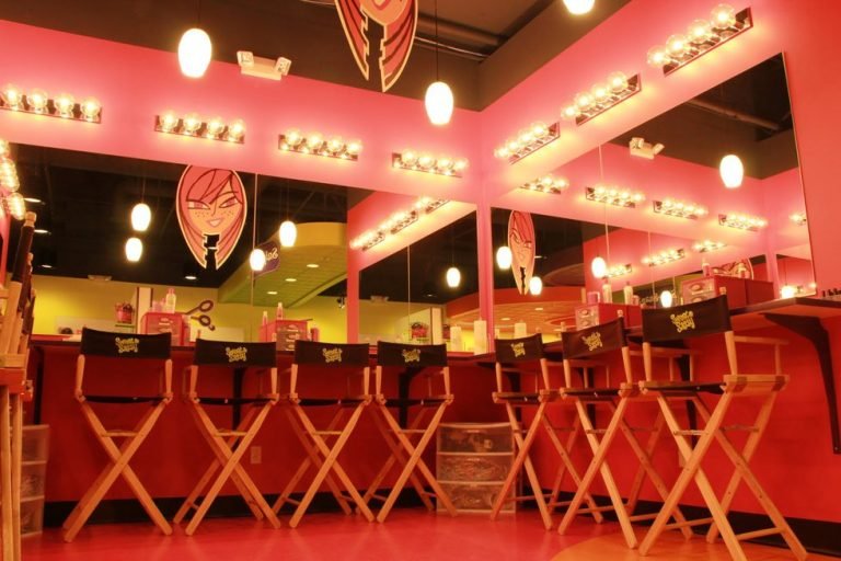 Kids haircuts and spa services St. Louis – Sweet & Sassy styling chairs in bright pink salon with vanity mirrors