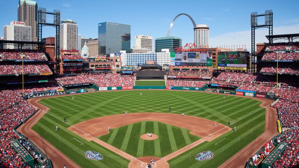 Busch Stadium in St. Louis packed with fans and Gateway Arch in the background