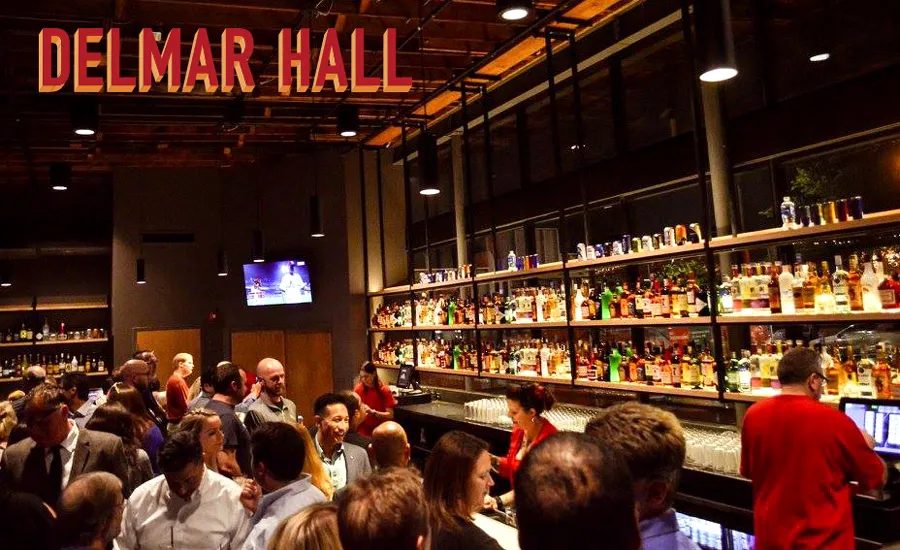 Crowded bar inside Delmar Hall concert venue in St. Louis, Missouri, with shelves of liquor and people gathering before a show