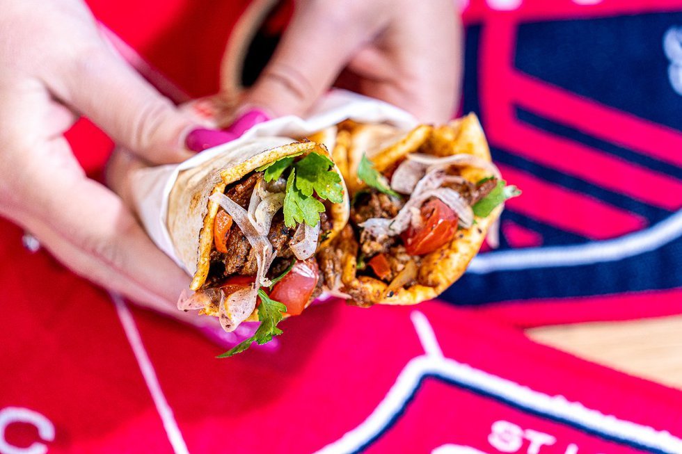 Close-up of a flavorful wrap with meat, onions, tomatoes, and fresh herbs served at Robin restaurant in Maplewood, St. Louis