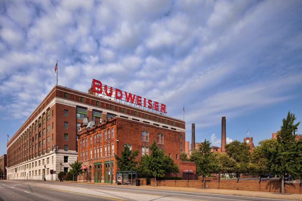 Historic Anheuser-Busch Brewery Tour building in St. Louis with the Budweiser sign under a bright blue sky