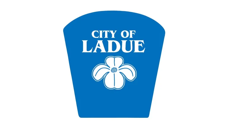 City of Ladue blue logo featuring a white flower, representing the community near homes for sale in Ladue MO.